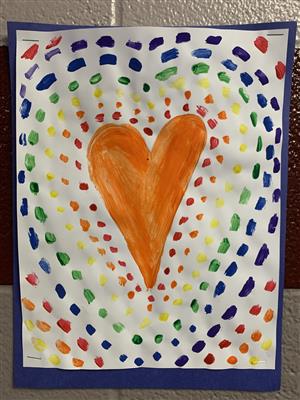 Photo is of a painting of a orange heart surrounded by dots of red, orange, green, blue and purple.